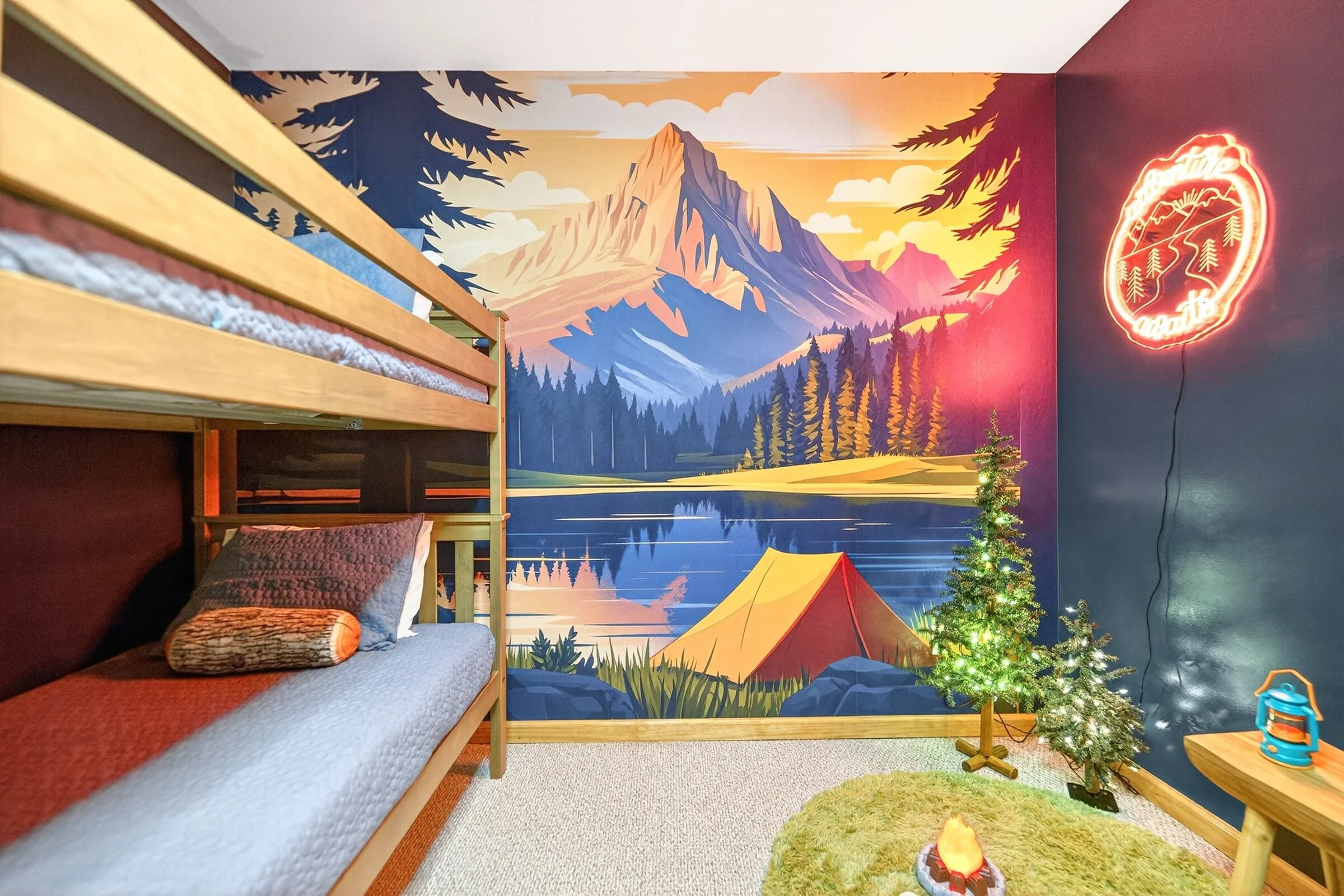 The bunk room mural and neon campfire, with a bunk bed in the foreground