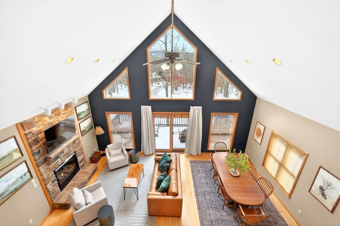 The A-frame window wall of the great room seen from the landing