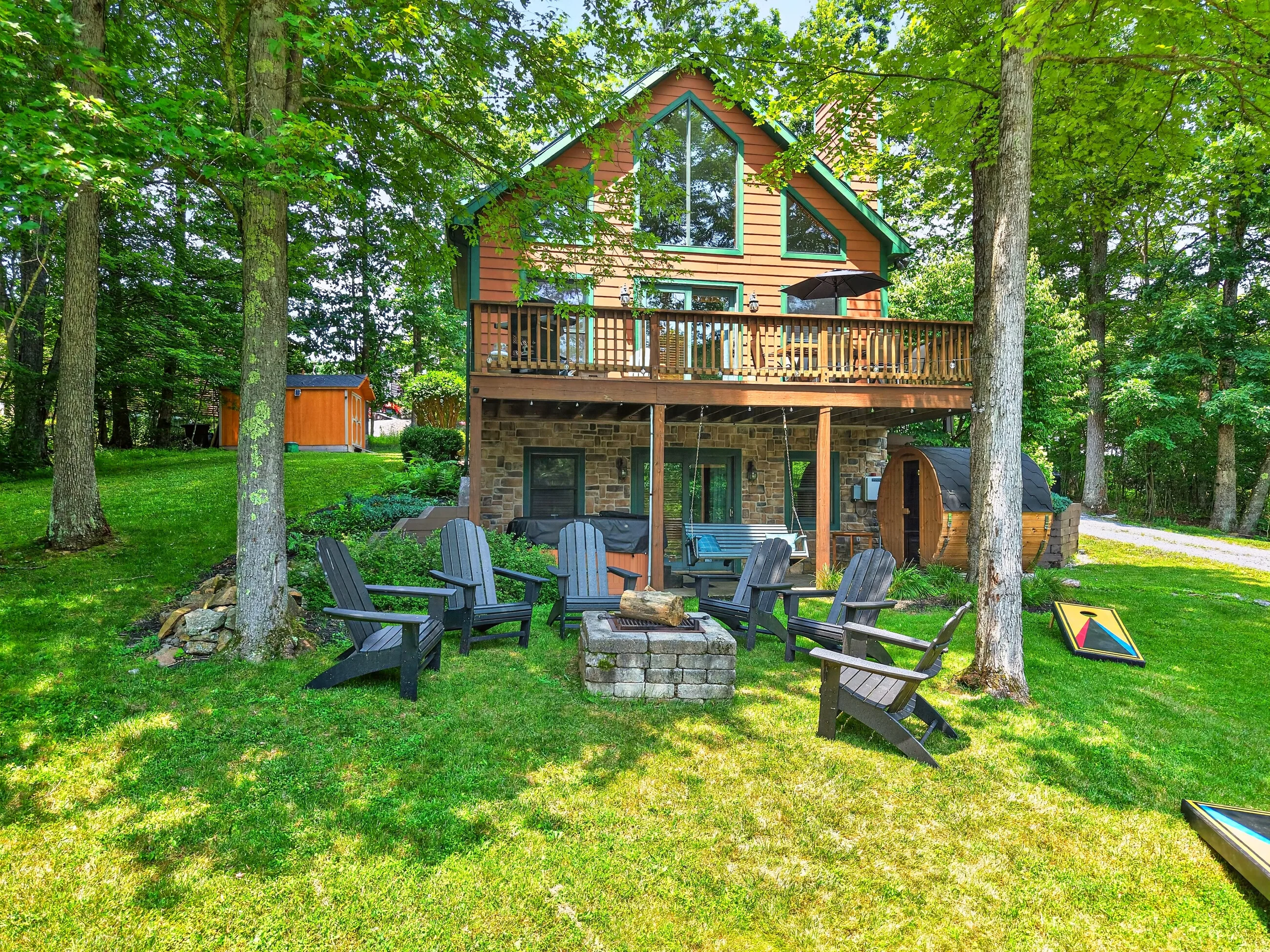 The chalet from the front lawn under full summer trees