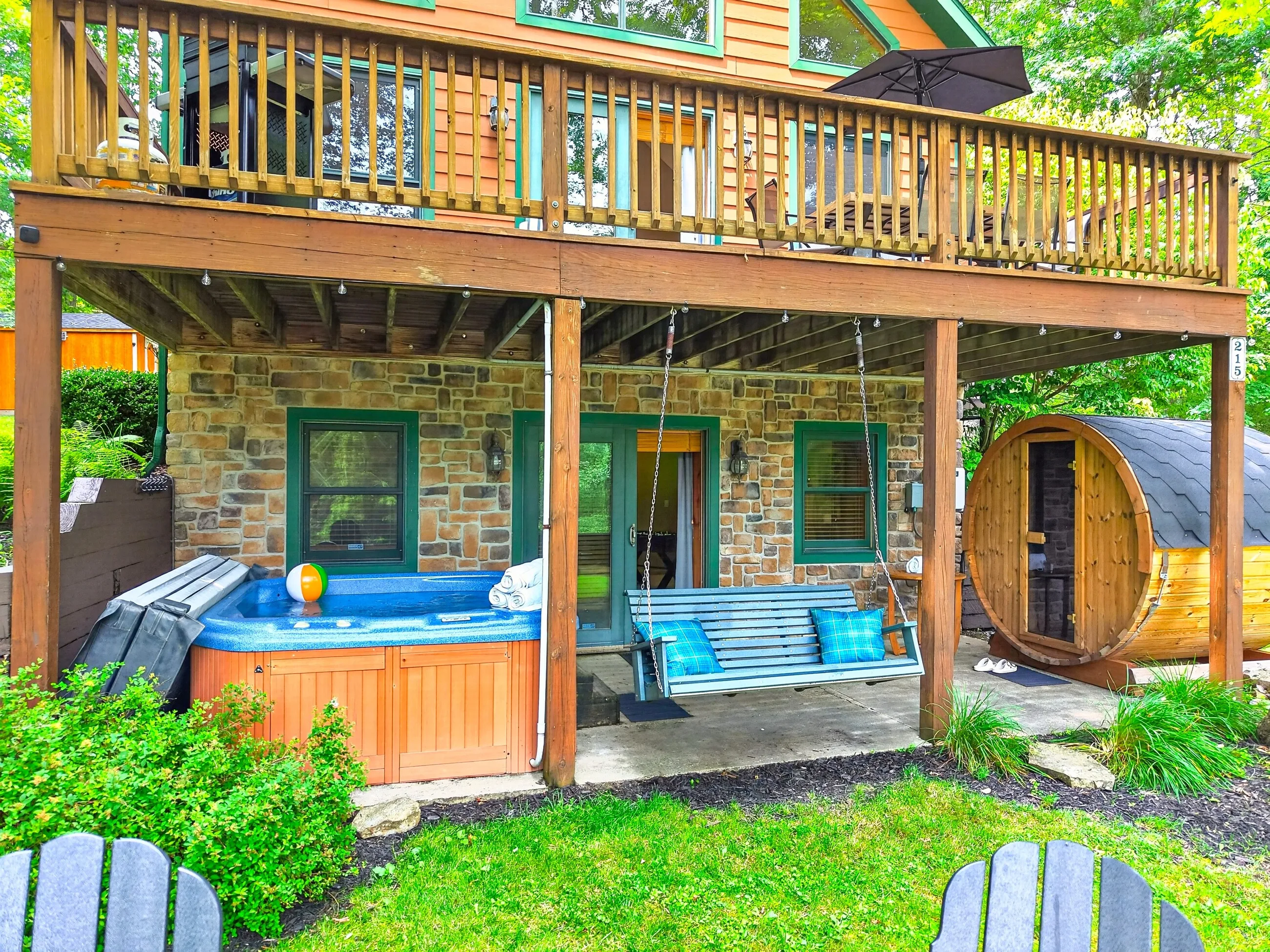 The house, hot tub and barrel sauna seen across the yard
