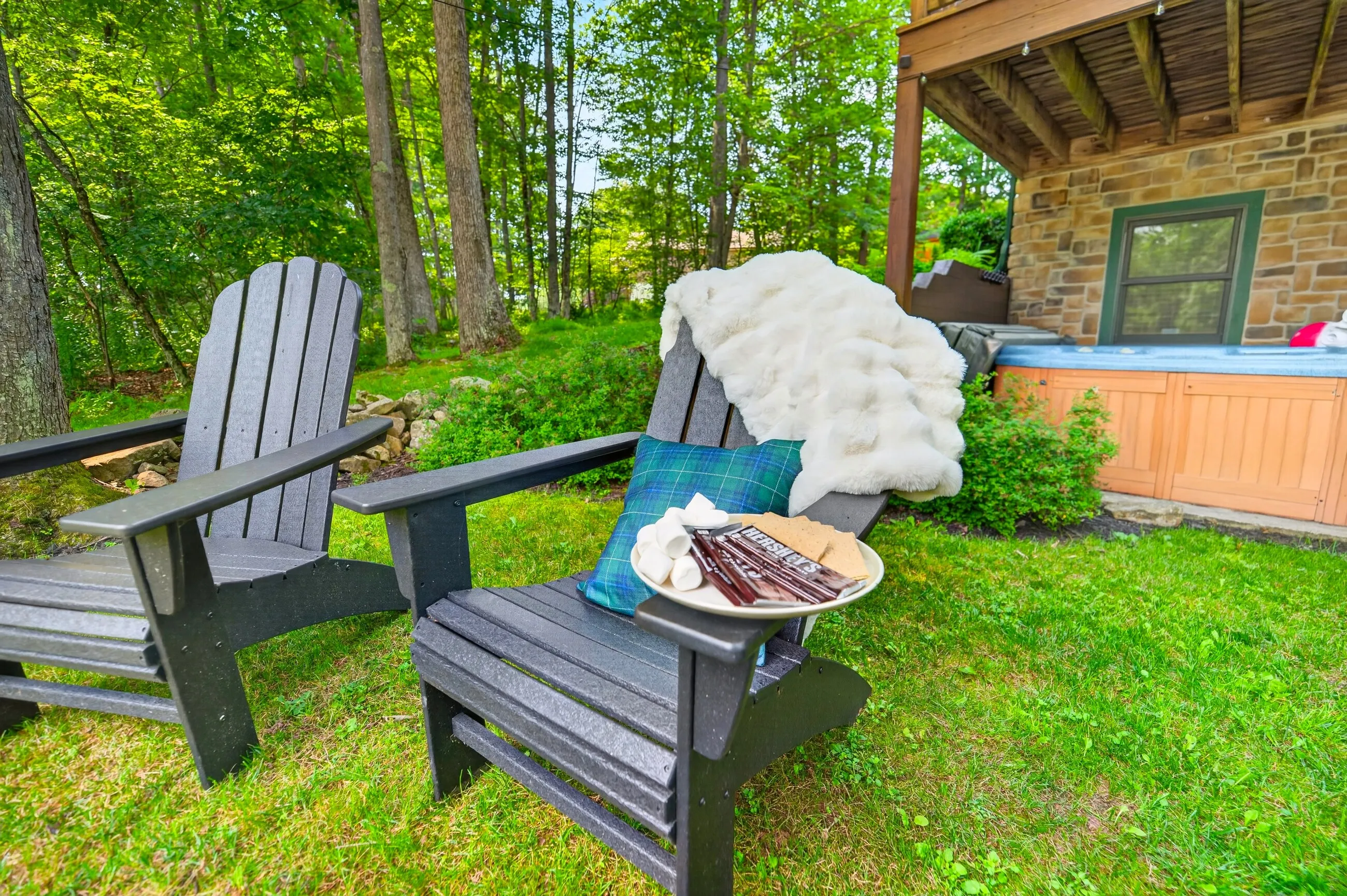 A blanket over an Adirondack chair and s'mores by the fire pit