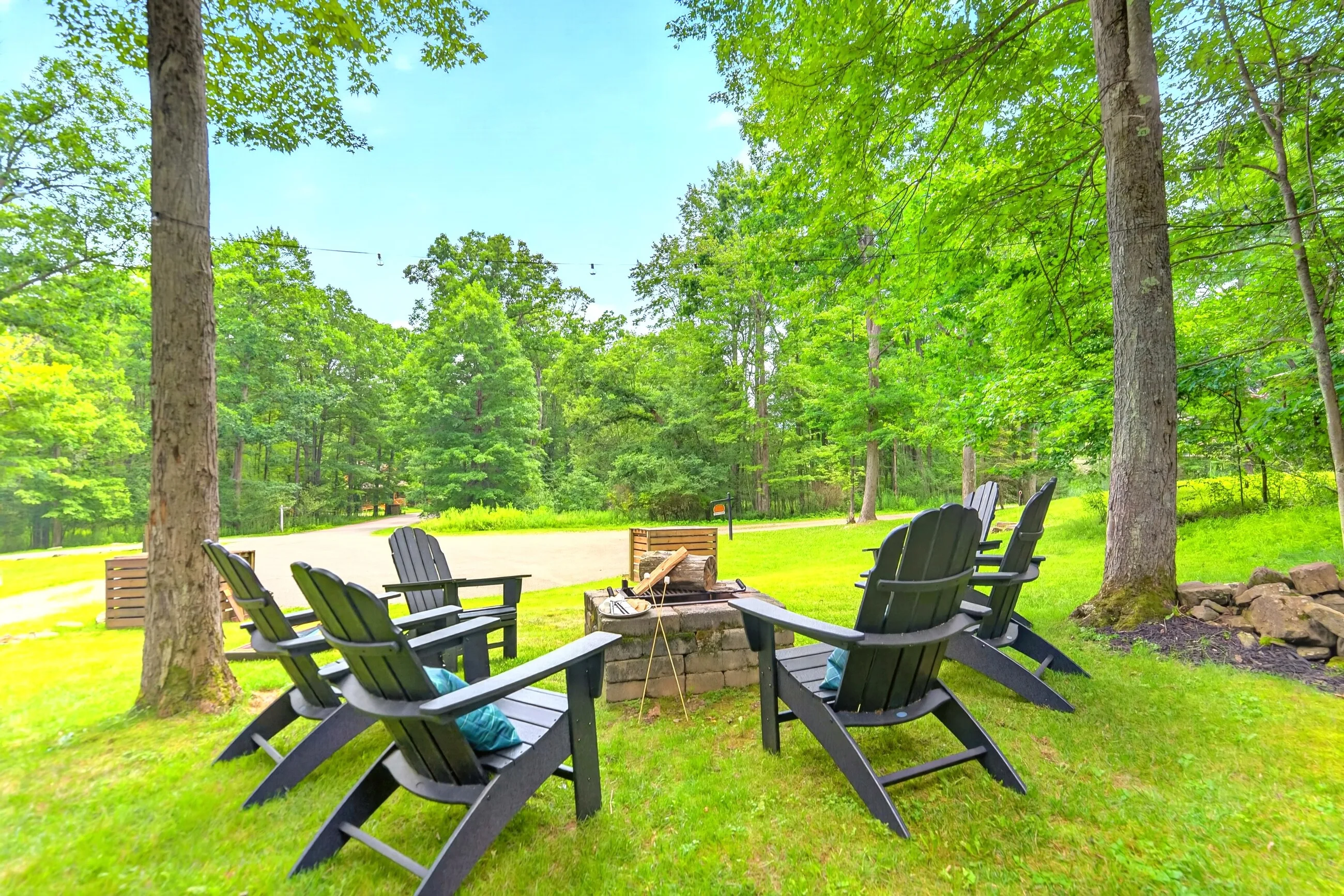 The stone fire pit ringed with chairs on the lawn